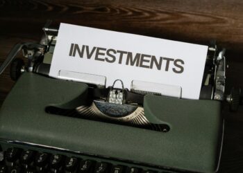 close-up mesin tik dengan kertas yang membaca investasi